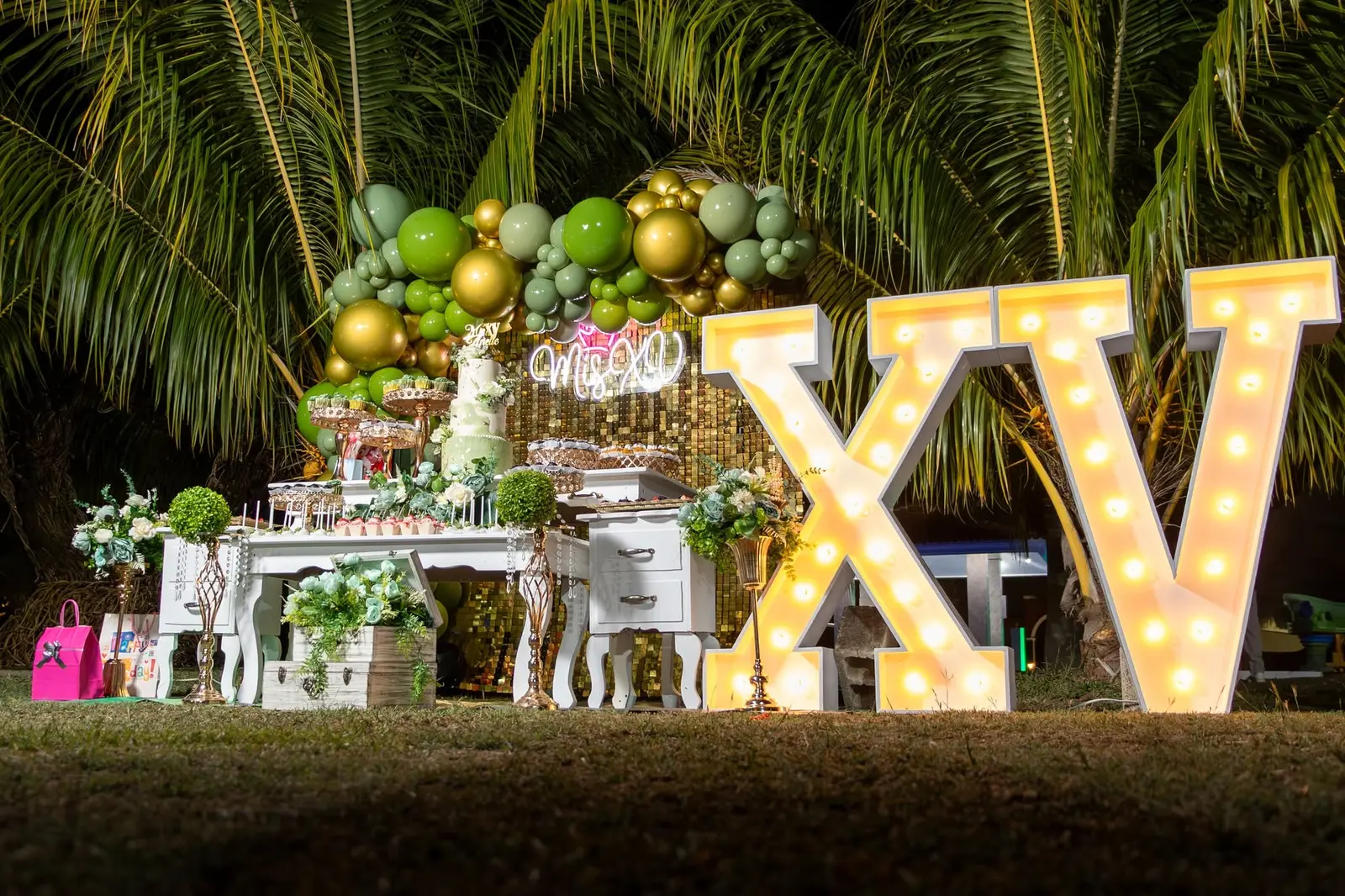 Letras XV iluminadas y mesa de dulces